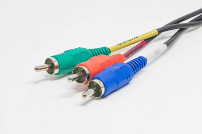 Close-up of red, green, and blue RCA connectors on a white surface, capturing vibrant color contrast.